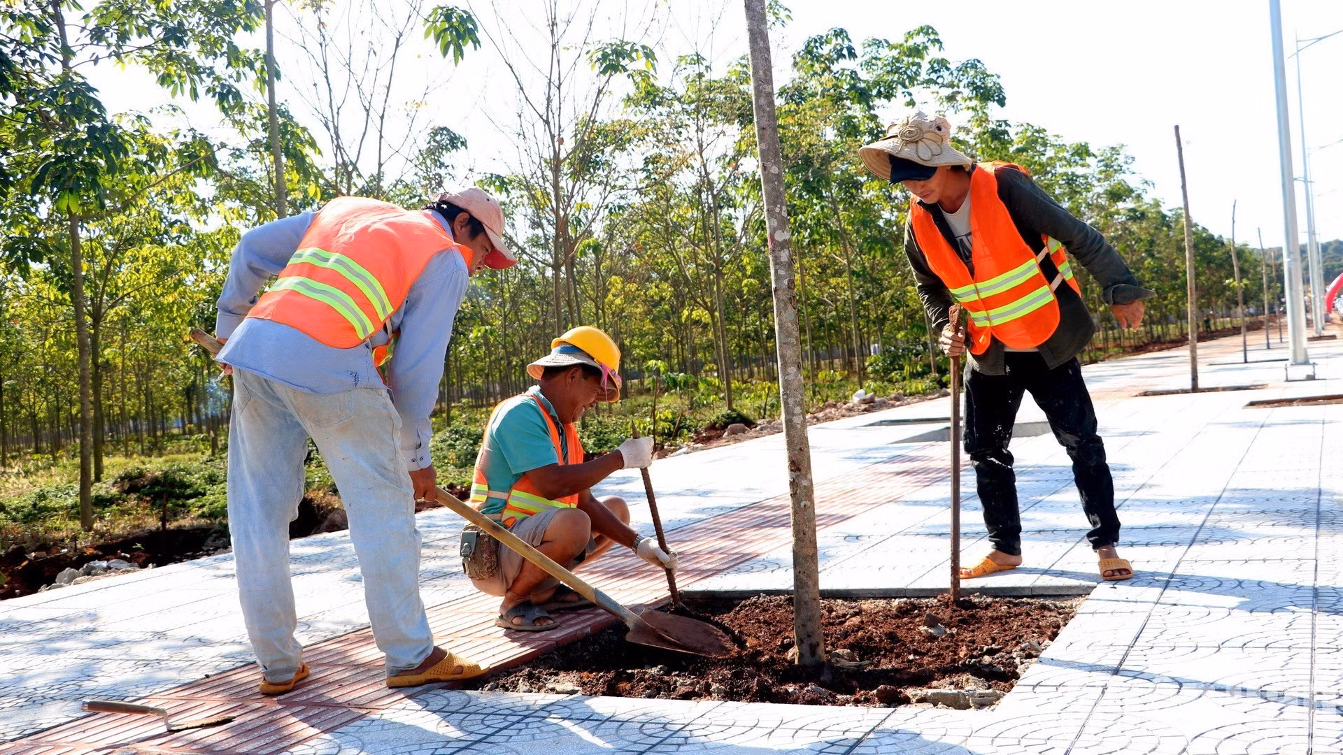 Des ouvriers réalisent les travaux des trottoirs de la route de ceinture 1 de Long Khanh.