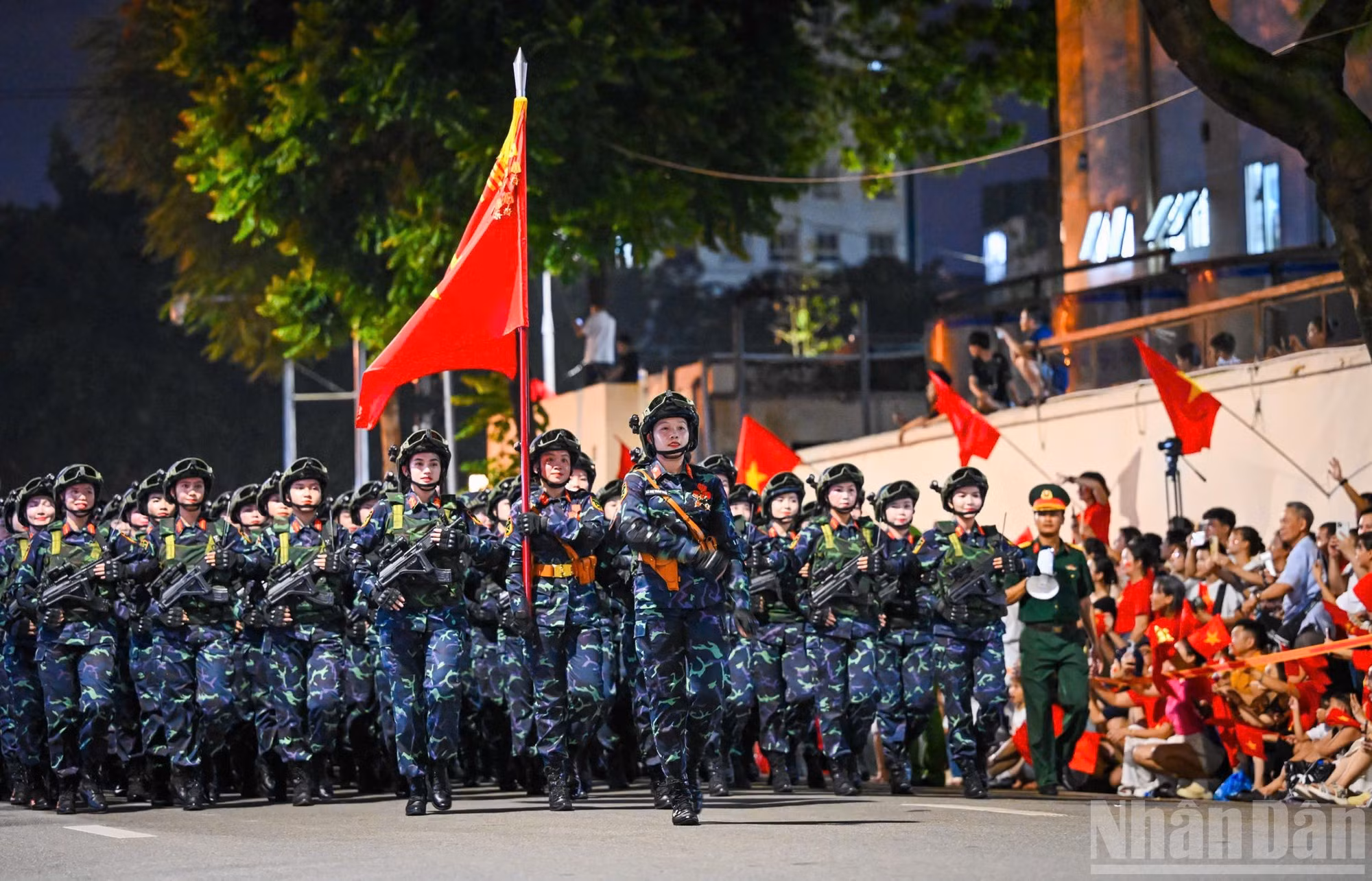 Bloc des combattantes de commandos, en tenue opérationnelle légère, marchant d’un pas régulier, le regard déterminé, incarnant à la fois la grâce et la fermeté, la douceur et la vaillance.