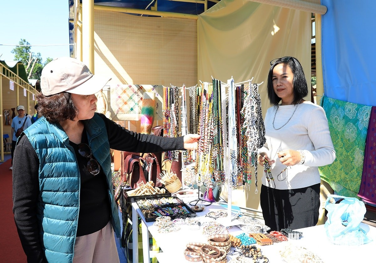 Mme Jusnah Binti Jinos (à droite), originaire de Malaisie, confie : « Je suis très heureuse de participer à cet événement culturel remarquable. Nous présentons ici des bijoux artisanaux imprégnés de la culture de notre pays. »