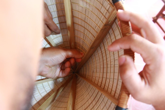 Il a trouvé le métier très intéressant, mais aussi très difficile lors de la couture du chapeau. Photo : Manh Doan. Il a trouvé le métier très intéressant, mais aussi très difficile lors de la couture du chapeau. Photo : Manh Doan.