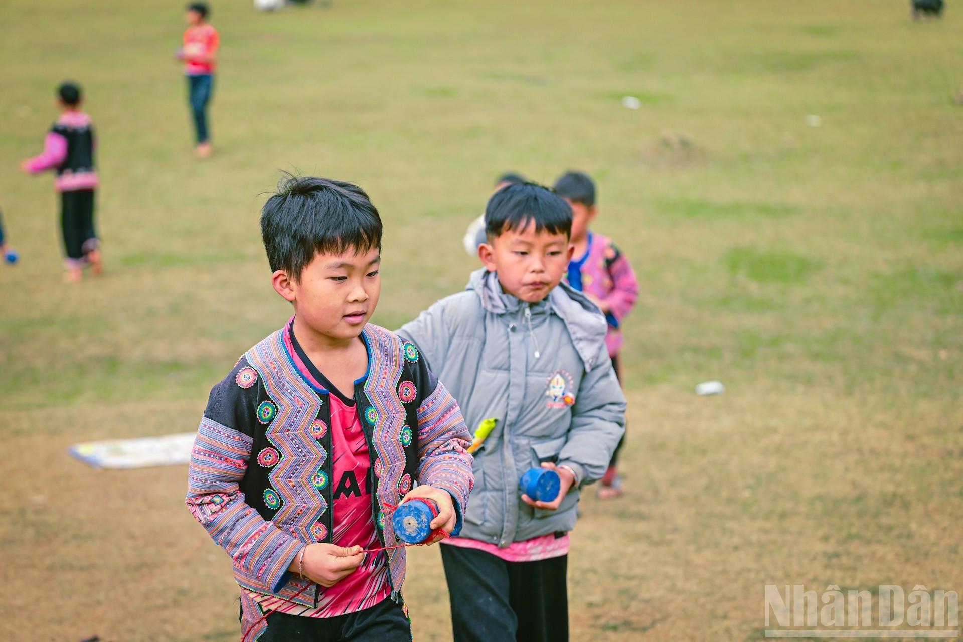 Les enfants de l’ethnie H’Mong, vêtus de costumes aux couleurs éclatantes, les joues rosies, jouent innocemment sur la prairie sans montrer de timidité lorsque les visiteurs les saluent avec bienveillance.