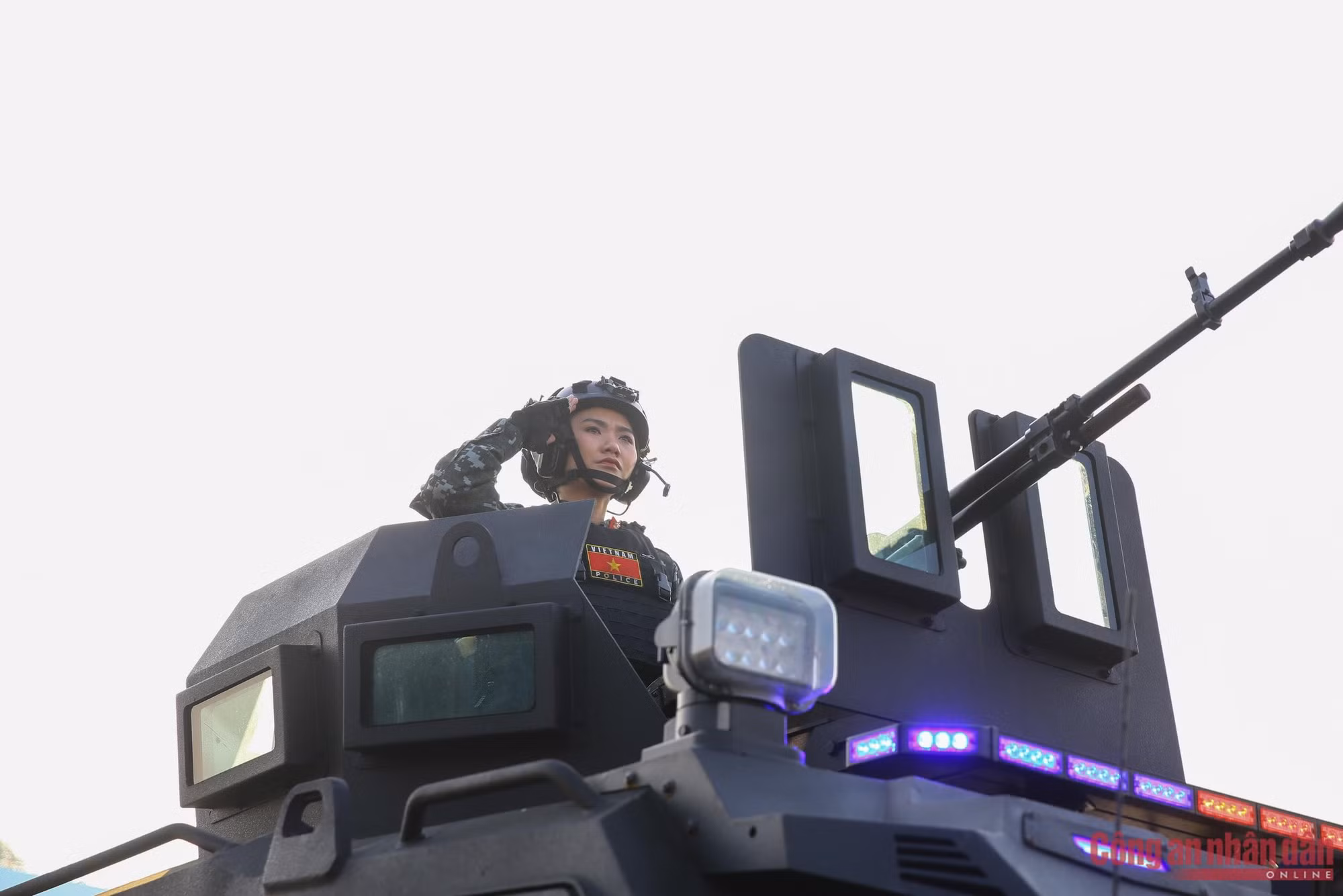 Une agente de la Police populaire vietnamienne salue solennellement depuis un véhicule blindé moderne. La cérémonie de déploiement et les exercices des plans de sécurité et d’ordre public au service du XIVe Congrès national des délégués du Parti sont prévus pour la matinée du 10 janvier 2025 à Hanoi.