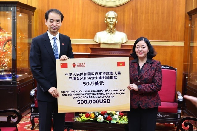 Mme Hoai reçoit une assistance financière de 500 000 dollars offerte par le gouvernement chinois. Photo : VNA