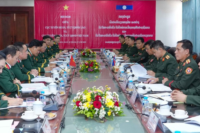 La délégation du Département de l&apos;éducation politique relevant du Département général de la politique de l&apos;Armée populaire vietnamienne (APV) s&apos;entretient avec celle du Département de l&apos;éducation politique de l&apos;Armée populaire lao. Photo: VNA