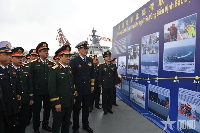 Le ministre vietnamien de la Défense Phan Van Giang et le ministre chinois de la Défense nationale Dong Jun visitent une exposition de photos sur d’anciennes patrouilles conjointes entre les marines des deux pays. Photo : qdnd.vn