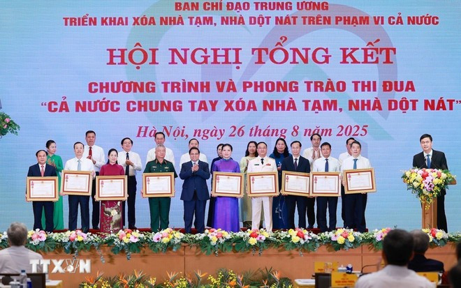 Le Premier ministre Phạm Minh Chính remet l’Ordre du Travail de troisième classe à des collectifs ayant obtenu des résultats remarquables dans le mouvement d’émulation “Tout le pays uni pour éliminer les habitations précaires et délabrées”. Photo: VNA. Le Premier ministre Phạm Minh Chính remet l’Ordre du Travail de troisième classe à des collectifs ayant obtenu des résultats remarquables dans le mouvement d’émulation “Tout le pays uni pour éliminer les habitations précaires et délabrées”. Photo: VNA.