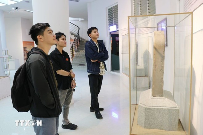 Des visiteurs découvrent et admirent des artefacts de la culture Cham exposés au Musée provincial de Khanh Hoa. Photo : VNA
