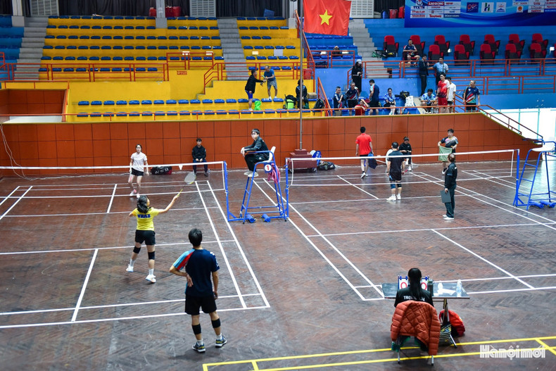 Les joueuses de badminton rivalisent en simple féminin, avec un rythme soutenu et des déplacements agiles, insufflant une ambiance de compétition dynamique.