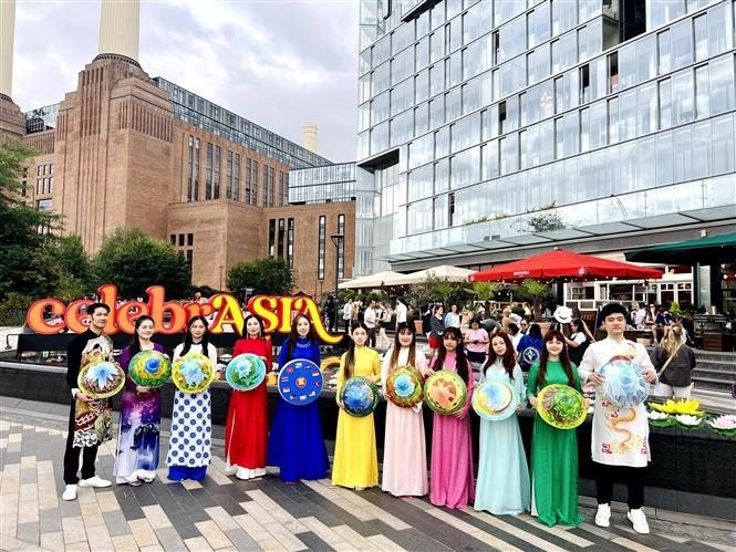 La délégation vietnamienne porte l'ao dai et les chapeaux coniques dans des rues de Londres. Photo : VNA La délégation vietnamienne porte l'ao dai et les chapeaux coniques dans des rues de Londres. Photo : VNA