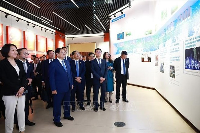 Le Premier ministre visite l'exposition thématique sur le développement et l’ouverture de Pudong. Photo : VNA. Le Premier ministre visite l'exposition thématique sur le développement et l’ouverture de Pudong. Photo : VNA.