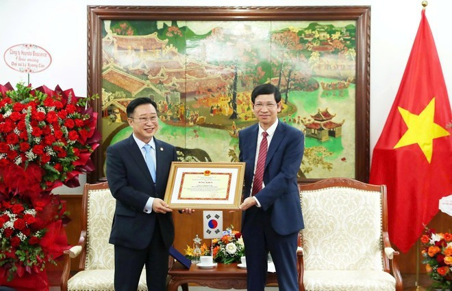 Le vice-ministre Ho An Phong remet le certificat de mérite du ministre de la Culture, des Sports et du Tourisme à l'ambassadeur du tourisme du Vietnam en République de Corée, Ly Xuong Can, en reconnaissance de sa contribution. Photo : Collaborateur/Vietnam+ Le vice-ministre Ho An Phong remet le certificat de mérite du ministre de la Culture, des Sports et du Tourisme à l'ambassadeur du tourisme du Vietnam en République de Corée, Ly Xuong Can, en reconnaissance de sa contribution. Photo : Collaborateur/Vietnam+
