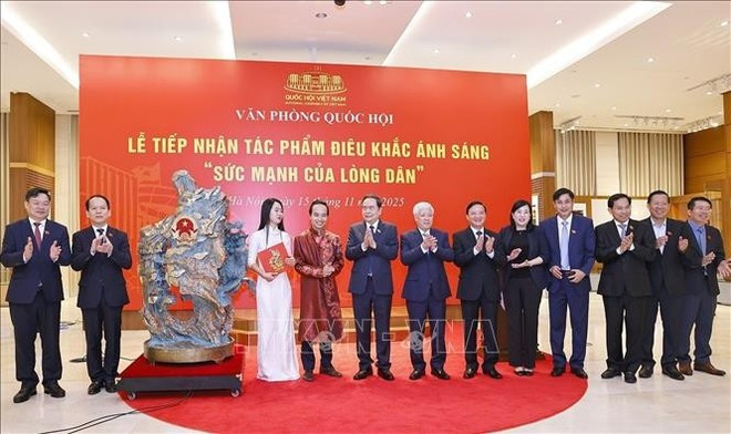 Le président de l&apos;Assemblée nationale, Tran Thanh Man, et des délégués en compagnie d&apos;artisans lors de la cérémonie de remise de la sculpture lumineuse. Photo : VNA