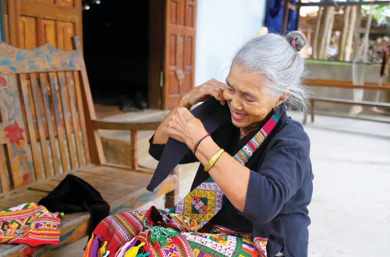 Mme Dung tient avec soin le foulard porté par les femmes O Du.