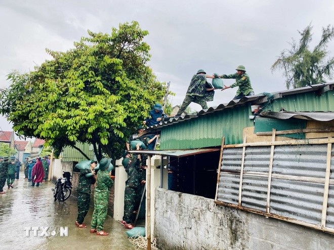 Des soldats renforcent les toitures des habitations. Photo : VNA. Des soldats renforcent les toitures des habitations. Photo : VNA.