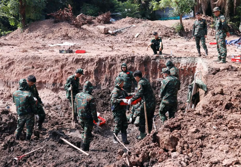 Malgré les conditions météorologiques difficiles, les soldats de l’équipe K74 accélèrent les recherches des restes de martyrs dans la zone B du parc Le Thi Rieng. Photo : VNA