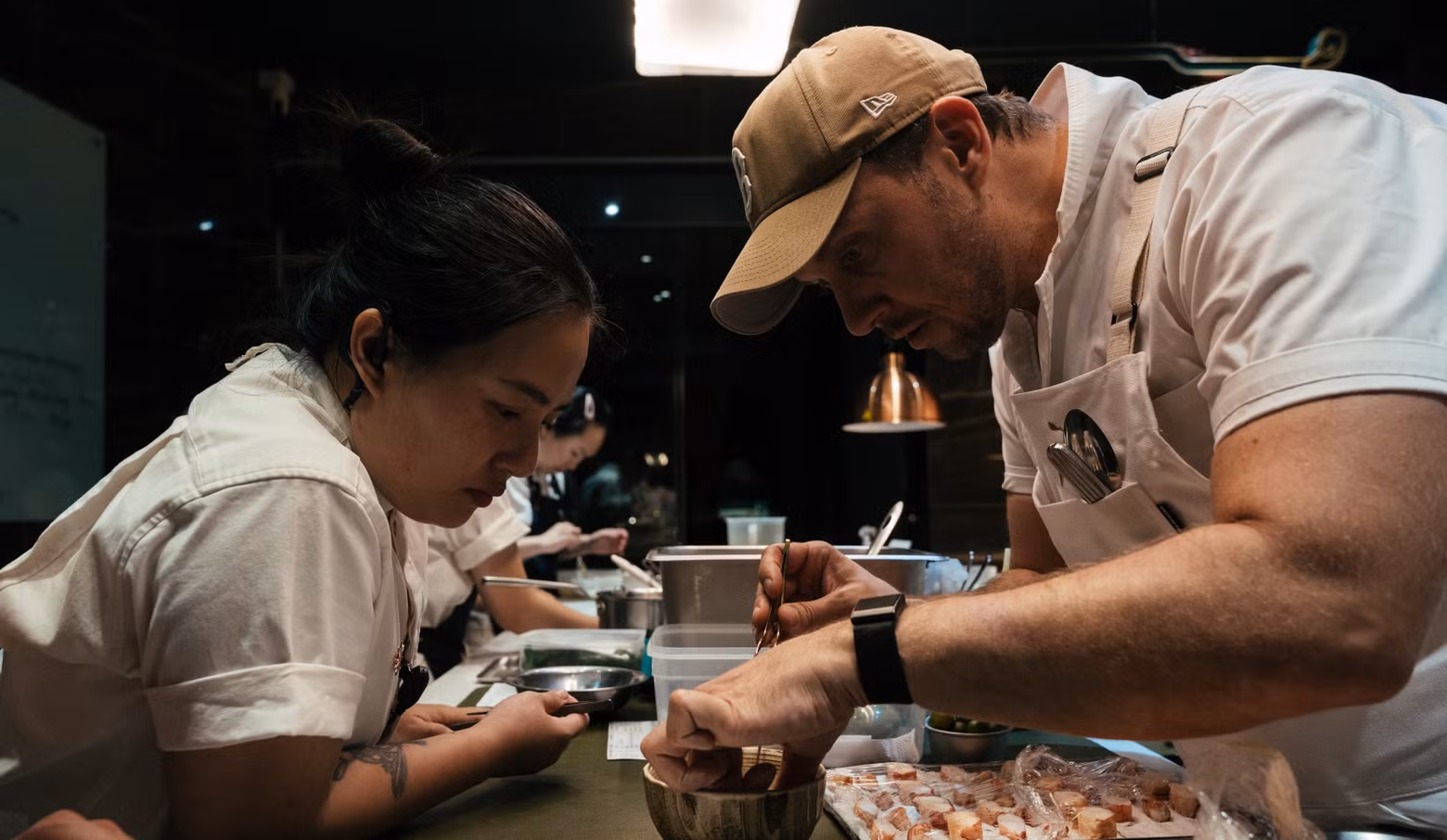Les chefs Darren MacLean et Sam Tran préparent ensemble des plats associant des ingrédients canadiens aux inspirations de la cuisine vietnamienne.