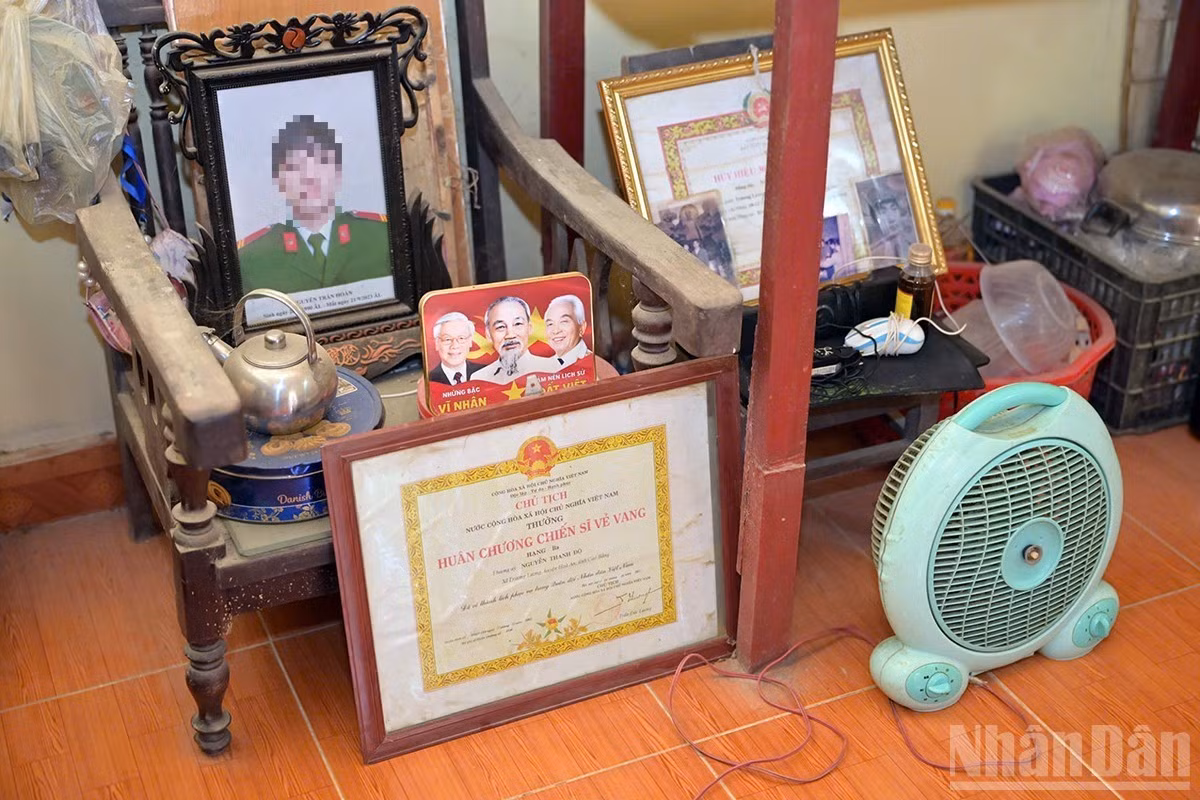 Les quelques objets que la famille de N.T.H. a pu sauver des inondations sont conservés au premier étage de sa maison fragilisée. Parmi eux figure le portrait funéraire de son père. Photo : Linh Phan