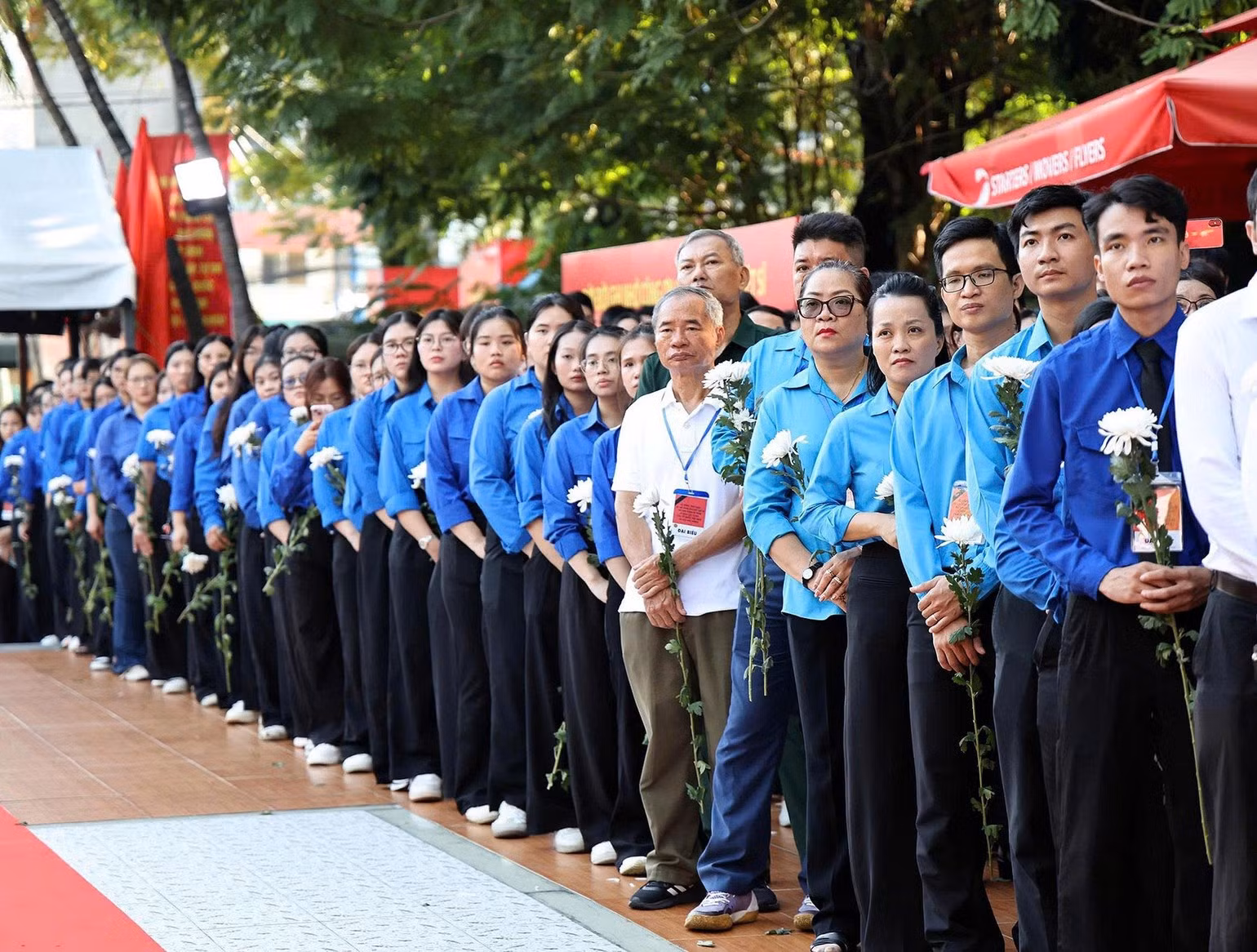 Des habitants font la queue pour se recueillir et accompagner les soldats vers leur dernière demeure. Photo : THU GIANG.