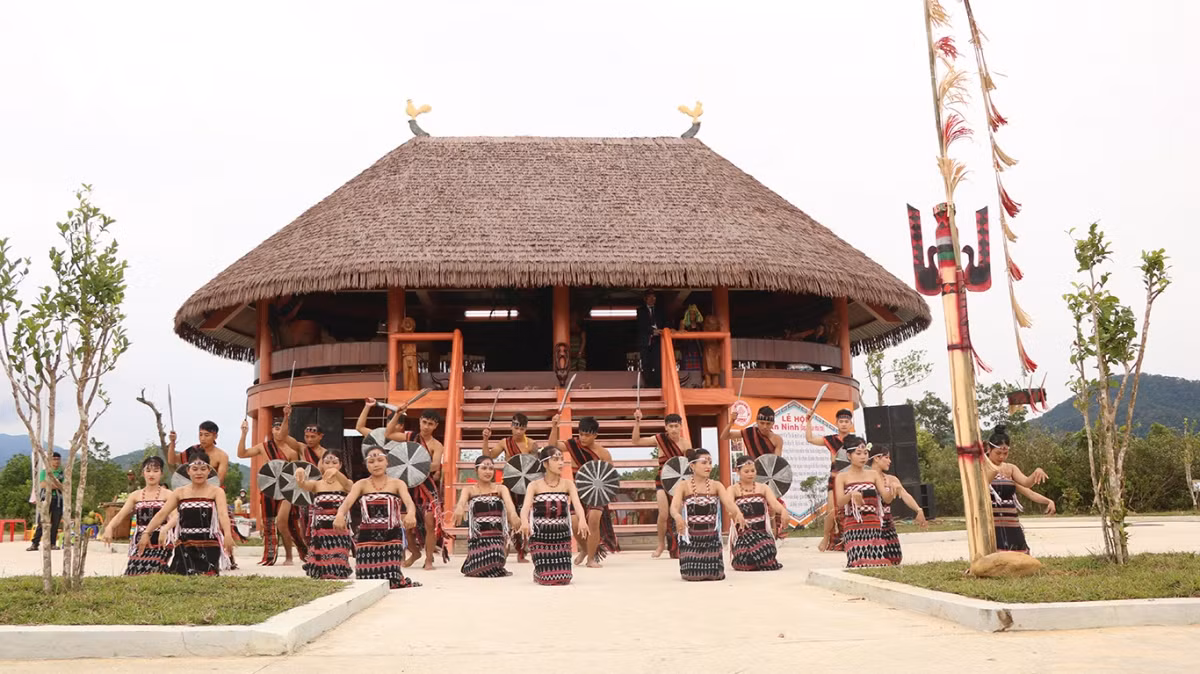 Garçons et filles de Cơ Tu à côté de la maison traditionnelle de Cơ Tu