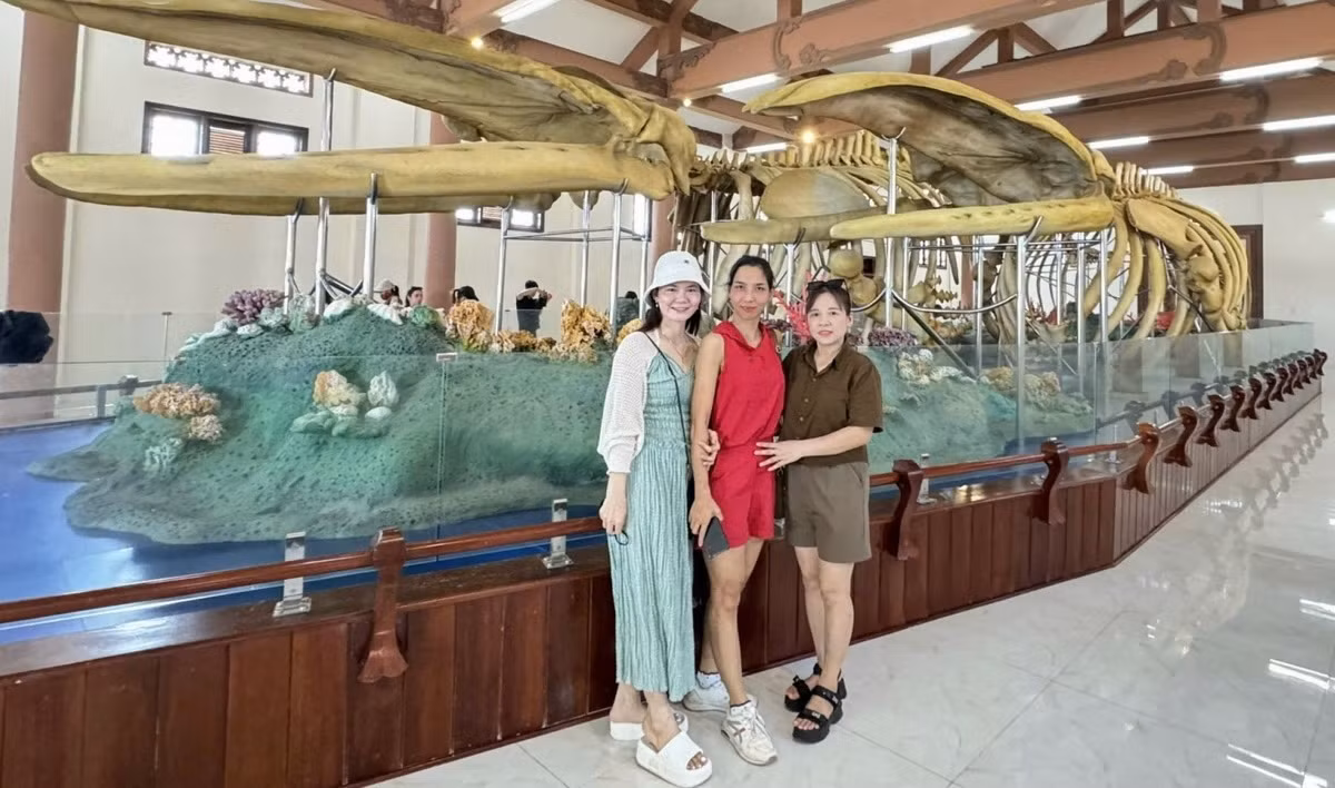 Des touristes prennent des photos de souvenirs avec deux squelettes de baleine. Photo : VOV.