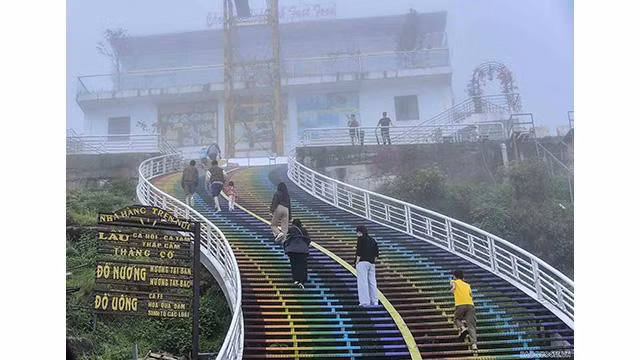 « L'arc-en-ciel de l'amour » est un point de prise de photos incontournable. Debout sur les hautes marches, les visiteurs peuvent capturer la vue panoramique depuis le pont sur les montagnes et les forêts. Photo: baoquocte.vn