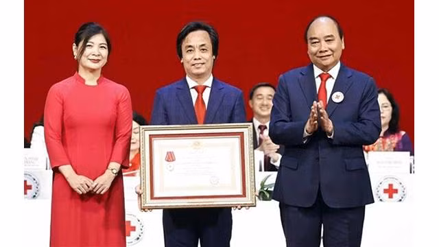 Le Président Nguyên Xuân Phuc (à droite) remet l'Ordre du Travail de 3e classe au Centre de télévision humanitaire relevant du Comité central de la Croix-Rouge du Vietnam. Photo: VNA