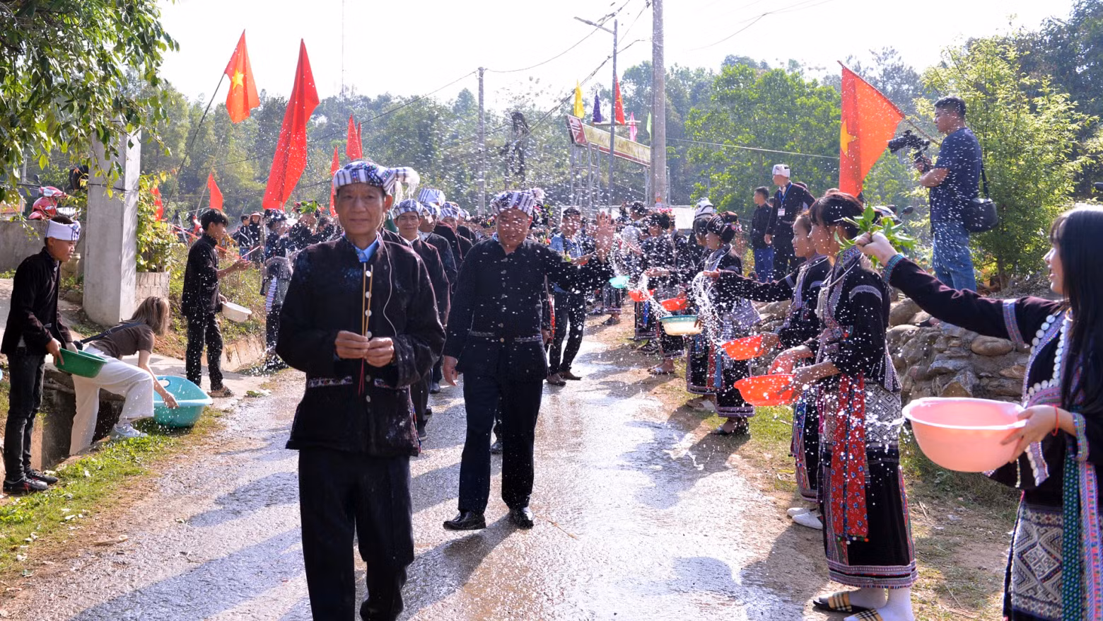 Sur le chemin du retour de l'eau, les familles du village jettent de l'eau sur les gens du groupe chargé de la cérémonie dans le but de prier pour la bonne chance pour toute l'année. Photo : nhandan.vn