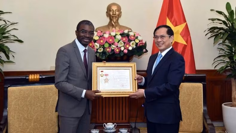 Le vice-Premier ministre et ministre vietnamien des Affaires étrangères, Bui Thanh Son (à droite), remet à Lazare Eloundou Assomo l'Insigne "Pour la cause de la diplomatie vietnamienne", pour honorer ses contributions exceptionnelles à la préservation et à la promotion des valeurs du patrimoine vietnamien, ainsi qu’au renforcement de la coopération entre le Vietnam et l'UNESCO. Photo: baoquocte.vn
