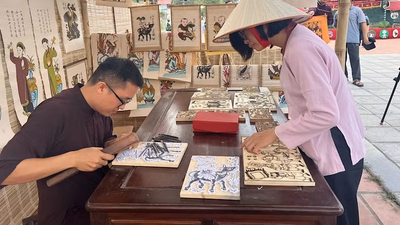 Le jeune artiste Nguyên Huu Dao présente une technique de création d’une estampe de Dông Hô. Photo : NDEL. Le jeune artiste Nguyên Huu Dao présente une technique de création d’une estampe de Dông Hô. Photo : NDEL.