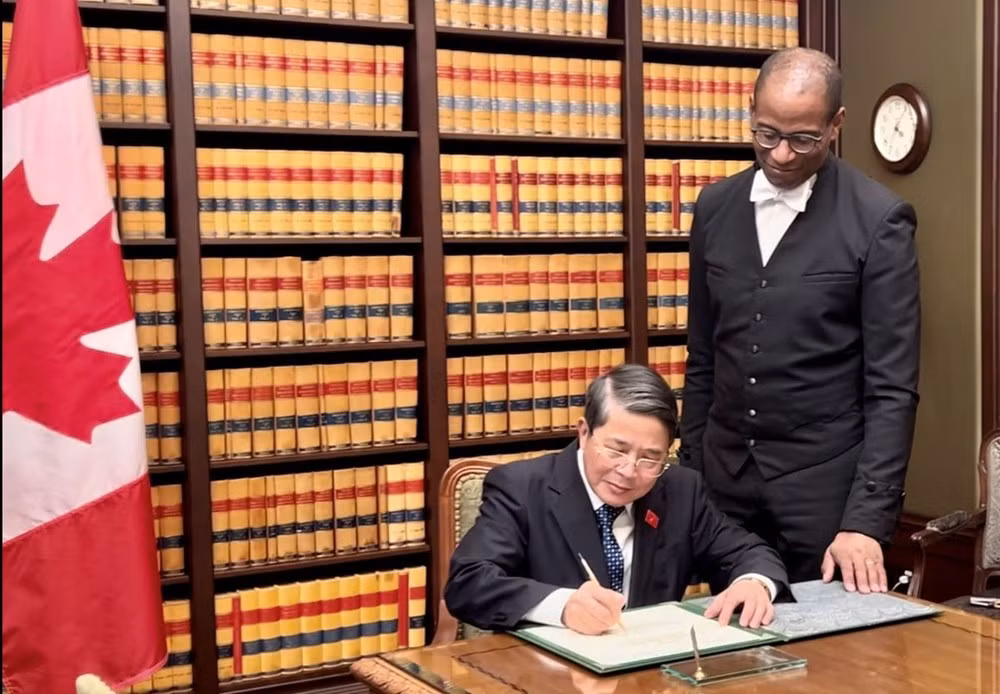 Le vice-président de l'AN Nguyen Duc Hai (à gauche) écrit dans un livre souvenir lors d'une rencontre avec le président de la Chambre des communes du Canada, Greg Fegus. Photo: VNA