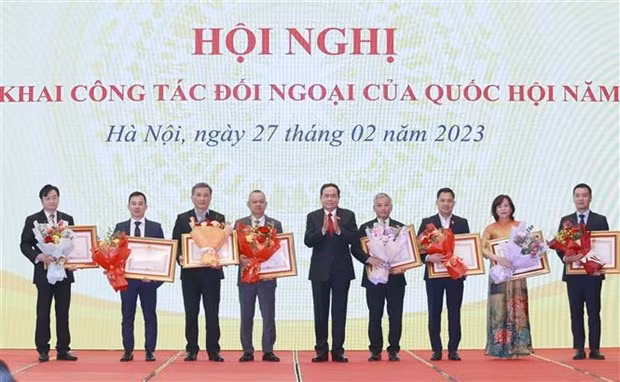 Le vice-président permanent de l’Assemblée nationale, Trân Thanh Mân, remettant des satisfecits du Premier ministre aux collectifs et particuliers pour leurs réalisations exceptionnelles. Photo : VNA.