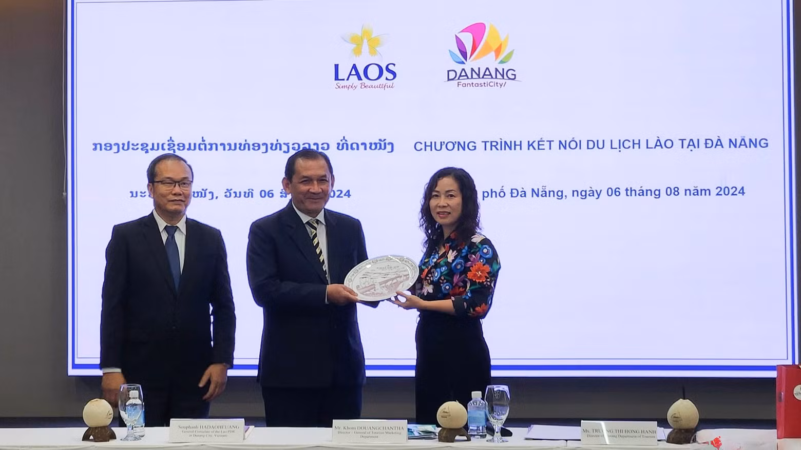 La directrice du Service du Tourisme de Dà Nang, Truong Thi Hông Hanh (1ère à droite) présente un cadeau de souvenir à M. Khom Douangchangtha, directeur du Département de la Promotion du Tourisme, relevant du ministère de l'Information, de la Culture et du Tourisme du Laos. Photo : toquoc.vn