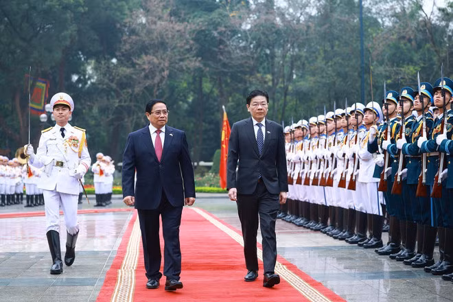 Le Premier ministre Pham Minh Chinh (gauche) préside la cérémonie d’accueil officielle à Hanoï en l’honneur de son homologue singapourien Lawrence Wong. Photo : VNA.