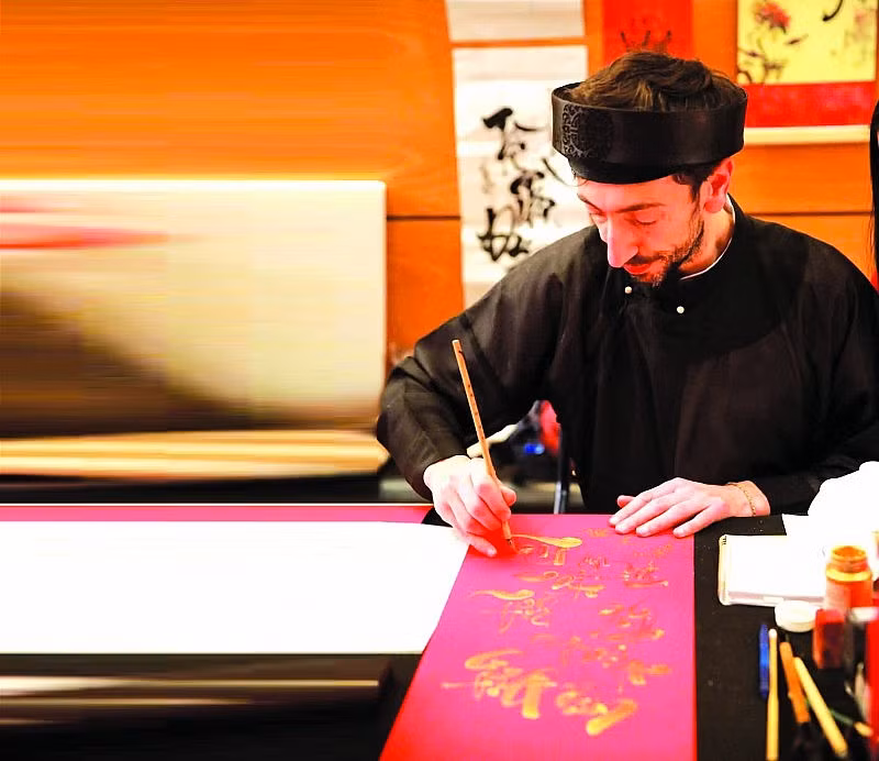 Captivé par la calligraphie, Jean Sébastien a décidé d’apprendre cette forme d’art. Photo : thoidai.com.vn