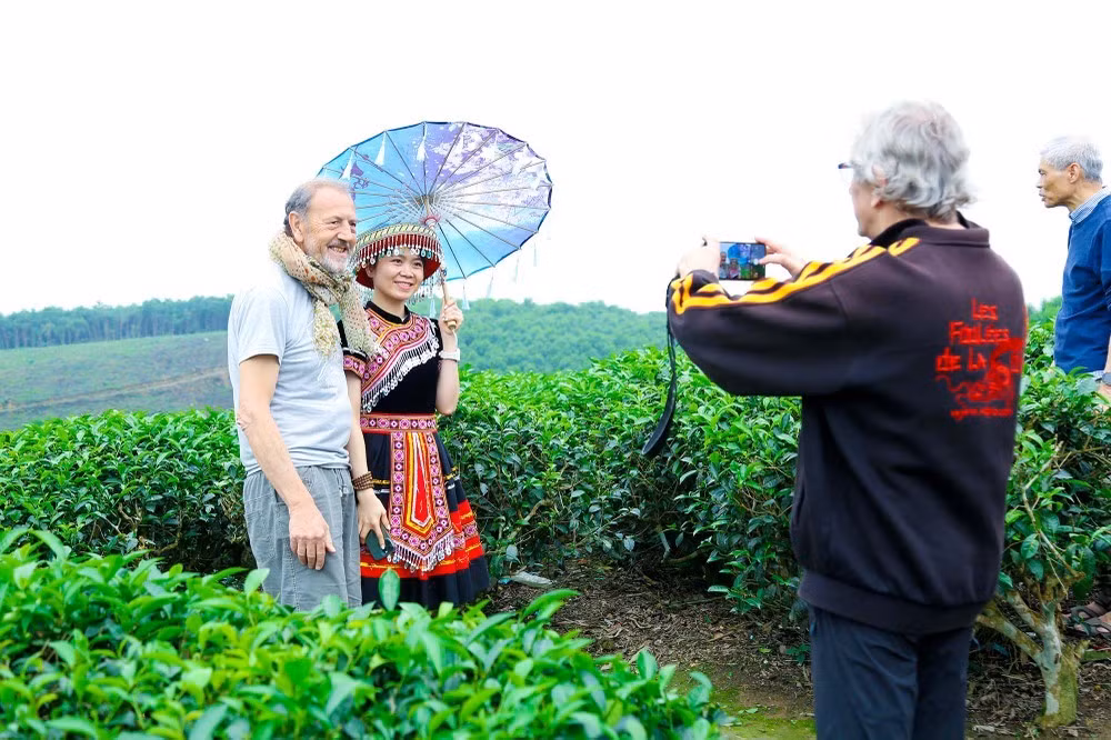 Les touristes français prennent des photos avec les locaux. Photo : Dinh Tuyên/baonghean.vn