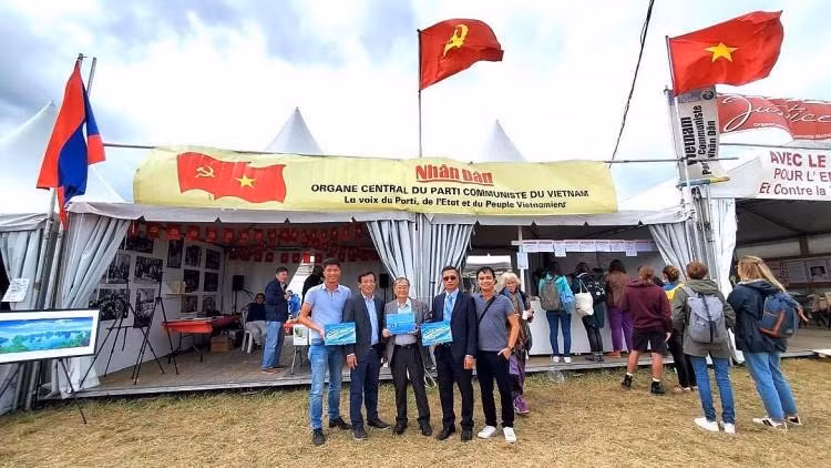 Nguyên Thanh Tong (3e à gauche) offre des livres aux amis à la Fête de l'Humanité en France. Photo : thoidai.com.vn