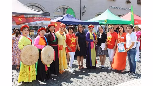 La maire de la ville d'Augsbourg Martina Wild (chemise noire, au centre), la rédactrice en chef du magazine "Huong Viêt" Pham Khanh Nam (à droite) et la communauté vietnamienne ont assisté à l'événement. Photo : VNA.