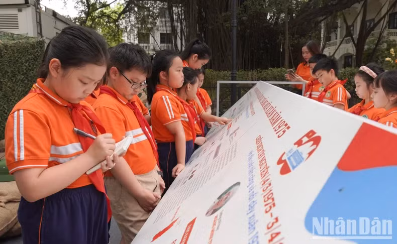 Les élèves notent les informations importantes de l’exposition pour rédiger leur compte rendu. Photo: nhandan.vn Les élèves notent les informations importantes de l’exposition pour rédiger leur compte rendu. Photo: nhandan.vn