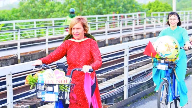 Mme Stella Ciorra lors d'un voyage à vélo pour promouvoir l'áo dài du Vietnam.