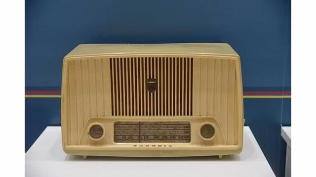 La radio GRUNDIG a été placée sur le bureau à côté du lit dans la chambre au deuxième étage de la maison sur pilotis de l'Oncle Hô. Photo : Musée Hô Chi Minh.