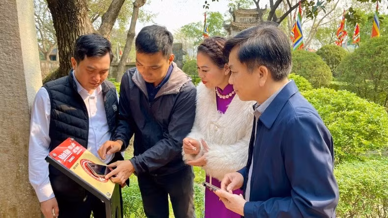 Les habitants de Ninh Bình testent le check-in sur les panneaux équipés de puces NFC du projet « Yêu lắm Việt Nam » du journal Nhân Dân.