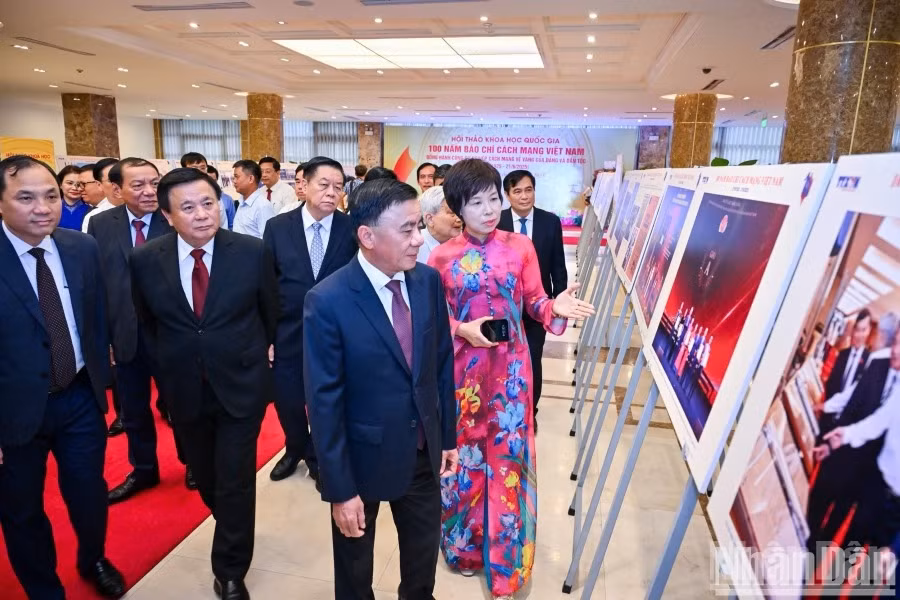 Des délégués visitent l'exposition photo thématique consacrée aux 100 ans de presse révolutionnaire vietnamienne, organisée par l’Agence vietnamienne d’information. Photo : NDEL.