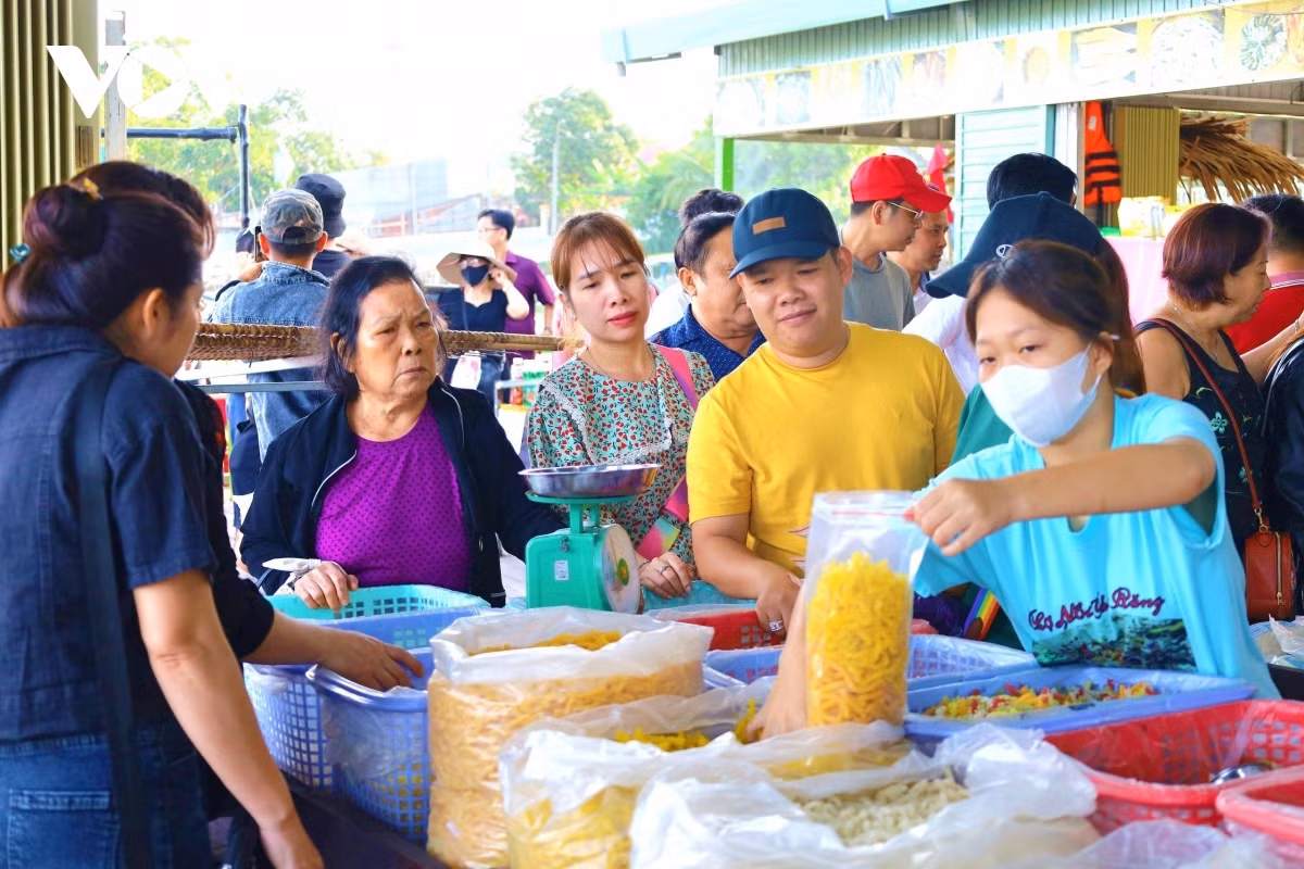 Les touristes s’essayent à la fabrication de gâteaux et achètent des spécialités traditionnelles sur le marché flottant Les touristes s’essayent à la fabrication de gâteaux et achètent des spécialités traditionnelles sur le marché flottant