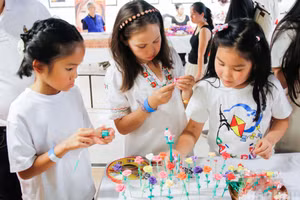 Des enfants s’initient avec enthousiasme au modelage des tò he sous la conduite d’artisans et de bénévoles.