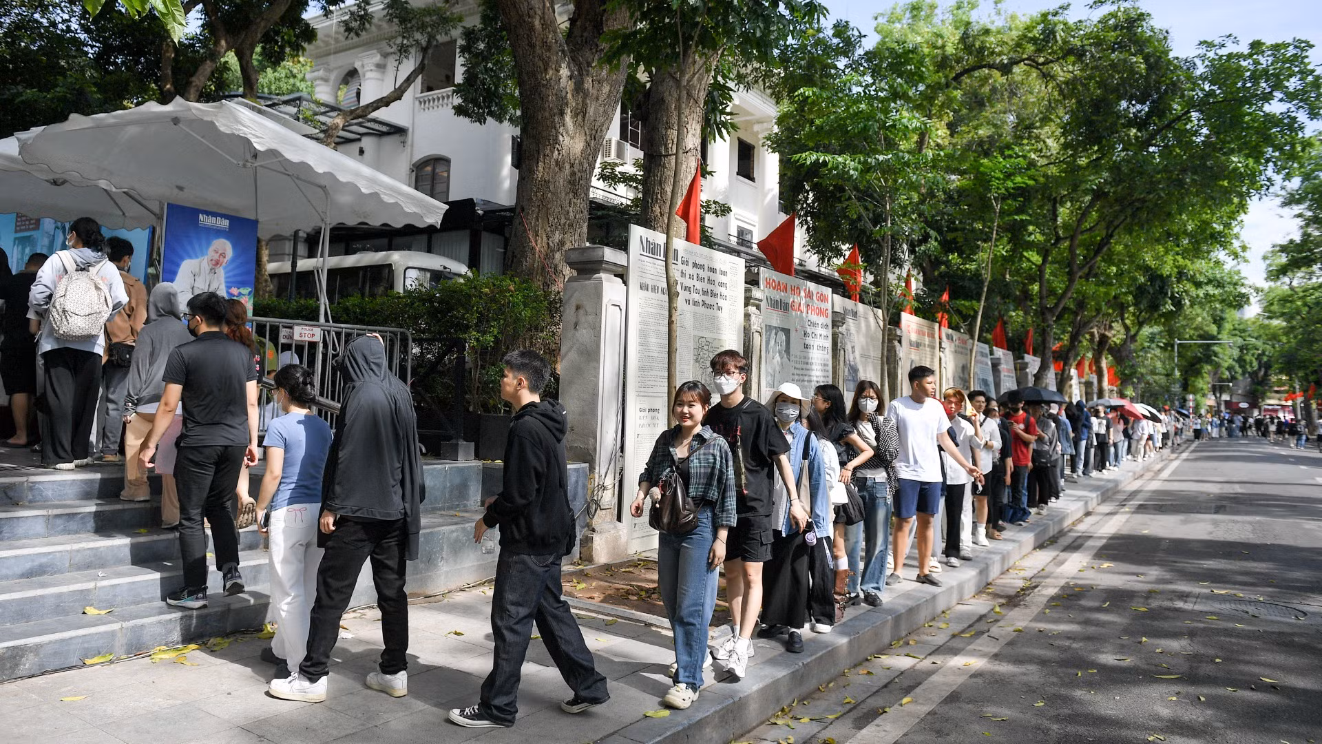 De nombreux jeunes font patiemment la queue pour recevoir le supplément spécial du Journal Nhân Dân