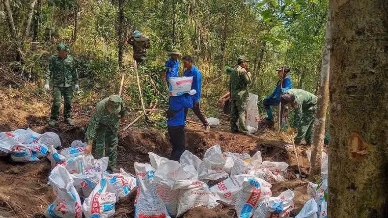 Les jeunes de la commune de Sin Thau, aux côtés des soldats du poste-frontière A Pa Chai, sont allés en forêt creuser et transporter des sacs de terre pour planter des arbres au pied de la tour de drapeau.