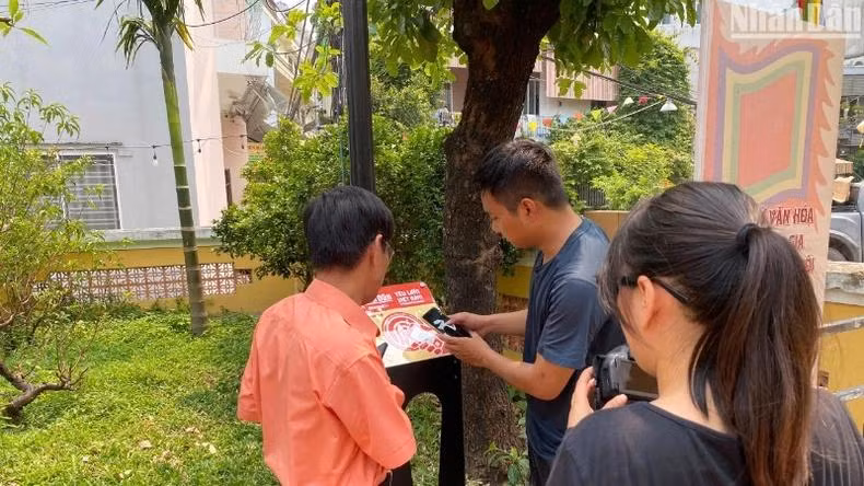 Installation d’un panneau équipé de puces NFC dans le cadre du projet « Yêu lắm Việt Nam » au site historique national de la maison communale du village de Hai Châu. Photo : NDEL. Installation d’un panneau équipé de puces NFC dans le cadre du projet « Yêu lắm Việt Nam » au site historique national de la maison communale du village de Hai Châu. Photo : NDEL.
