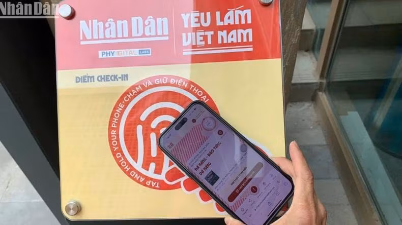 Les touristes scannent un panneau équipé de puces NFC au Musée de Da Nang. Photo : NDEL.