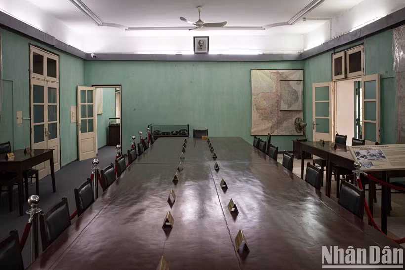 La table de réunion est placée au centre de la salle, orientée dans le sens est-ouest. Des quatre petites tables situées aux côtés nord et sud, chacune est réservée aux secrétaires des réunions. Actuellement, sur la table principale sont disposées des plaques en bronze portant les noms des 24 camarades ayant pris part à la réunion élargie du Bureau Politique à la fin de l’année 1974 et au début de 1975. La table de réunion est placée au centre de la salle, orientée dans le sens est-ouest. Des quatre petites tables situées aux côtés nord et sud, chacune est réservée aux secrétaires des réunions. Actuellement, sur la table principale sont disposées des plaques en bronze portant les noms des 24 camarades ayant pris part à la réunion élargie du Bureau Politique à la fin de l’année 1974 et au début de 1975.