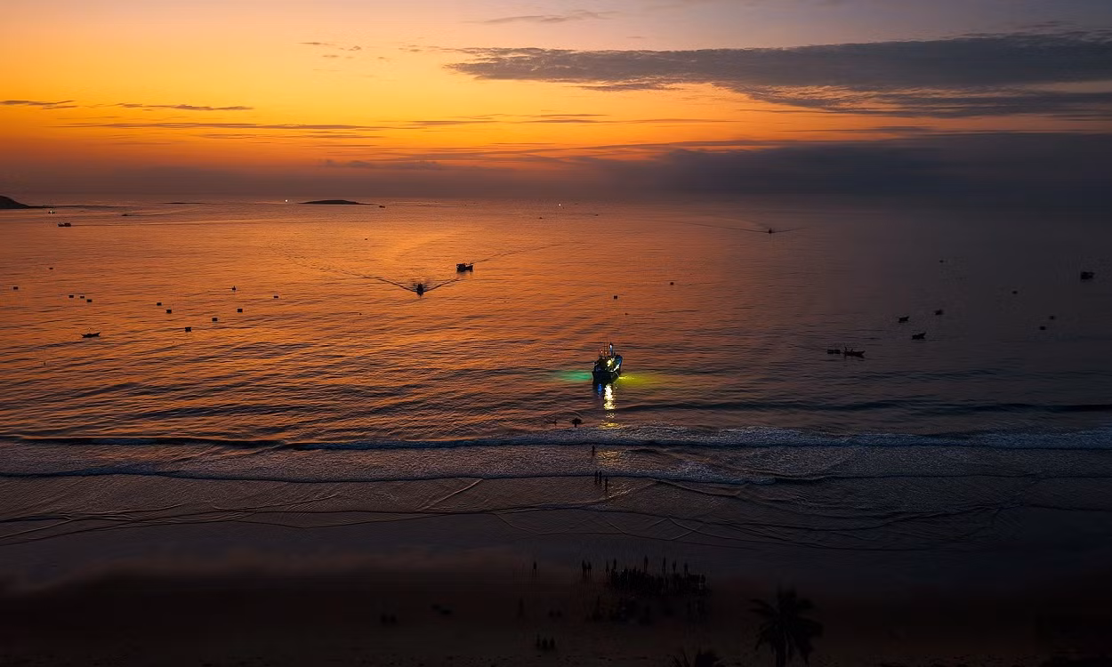 On voit le village de Long Thuy à l’aube, avec au loin les bateaux de pêche nocturne qui rentrent au port de pêche. Photo : Vnexpress.